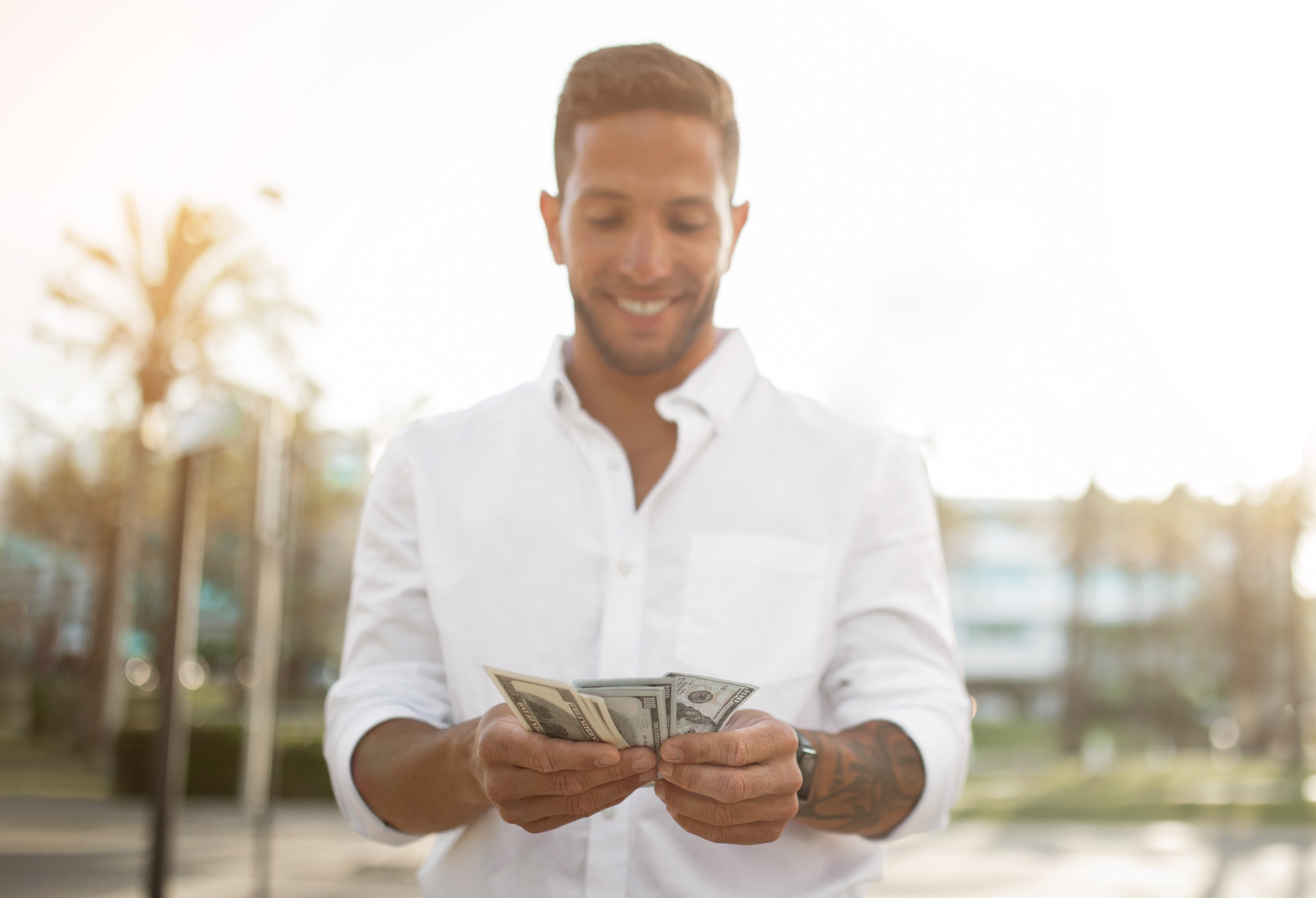 First salary. Happy young businessman holding fan of money, celebrating financial luck and success