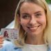 Cheerful Caucasian lady smiling female girl auto transport owner demonstrating driver license in